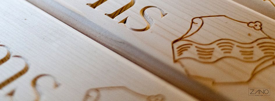 Holzverarbeitung und Personalisierung der Bestellung durch das Hinzufügen des Wappens und Namens der Stadt auf der Sitzbank.